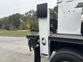 Side view of a 2013 Freightliner 114SD truck showing the equipment storage compartment and a towing hitch attached to the rear
