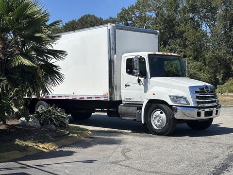 A white 2020 Hino 338 box truck with a large cargo area and a silver front grille parked on a paved surface
