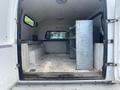 Interior of a 2014 Ford F-350 SD with metal shelving on one side and a bench seat on the other side