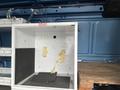 A 2006 Ford Econoline van interior featuring a white storage cube with visible peeling paint and a black floor mat inside the cube