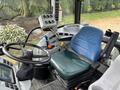 A 2009 New Holland T4020 tractor interior featuring a blue seat a steering wheel and various control switches and levers