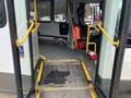 Interior view of a 2020 Chevrolet Express showing the open doors a wheelchair ramp and the driver's seat