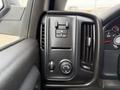 The interior control panel of a 2018 Chevrolet Silverado 1500 featuring buttons for seat adjustments and a dial for the headlight settings