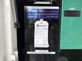 A 2011 Ford F-650 with a service sticker attached to the driver's side door detailing maintenance information and a contact for Power-West industries