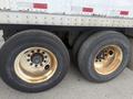 Close-up of two large, rusted truck wheels with visible wear and tear highlighting the steel rims and rubber tires in a weathered condition