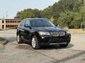 A 2013 BMW X3, a black luxury SUV, featuring a modern design with a distinctive kidney grille and alloy wheels parked on a gravel surface