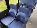 Two blue fabric seats with safety belts positioned in a vehicle, designed for passenger comfort and safety