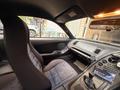Interior of a 1997 Toyota Supra featuring sporty seats a dashboard with various controls and a touchscreen display on the center console