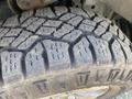 Close-up of a rugged tire tread from a 2014 Ford F-150 showing deep grooves and a distinctive pattern indicating off-road capability