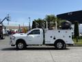 A white 2020 Ram 2500 truck with a service body featuring storage compartments and a mounted generator in the truck bed