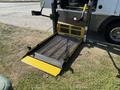 A 2020 Chevrolet Express with a deployed yellow and black wheelchair ramp in the foreground