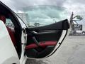 A white 2016 Maserati Ghibli with a partially open door showcasing a red interior and modern design elements