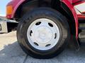 A close-up of a white wheel with a Firestone tire on a red truck from 1991 International 4600