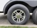 A close-up view of a shiny aluminum wheel with a multi-spoke design and a large black tire featuring visible tread patterns