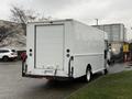 A white 2018 Ford E-450 box truck is parked with its rear facing the viewer showing a plain rear door without any visible markings or logos