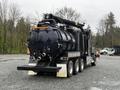 A 2018 Kenworth T800 truck with a vacuum tank trailer featuring a large black cylindrical tank and various equipment attached on top