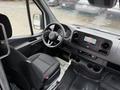 Interior view of a 2023 Mercedes-Benz Sprinter showing the dashboard steering wheel and front seats with a digital display and climate controls