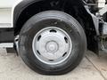 A close-up of a wheel and tire from a 2009 UD Trucks UD 3300 featuring a metallic rim and a treaded black tire