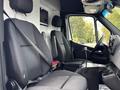 Interior view of a 2020 Mercedes-Benz Sprinter 2500 showing two black fabric seats with seatbelts and a central console