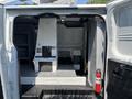 Interior view of a 2019 Ford Transit 350 showcasing an empty cargo area with a raised platform and storage compartments