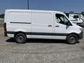 White 2022 Mercedes-Benz Sprinter van with a plain side and no visible markings parked on gravel
