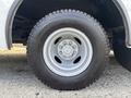 A close-up of a 2018 Ford Econoline tire featuring a silver wheel rim with multiple bolts and a rugged tire tread design