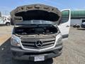 A 2016 Mercedes-Benz Sprinter van with its hood raised showing the engine compartment