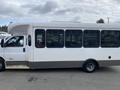 A white 2020 Chevrolet Express bus with a rectangular shape and large windows on the side