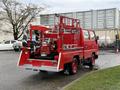 Red 2001 Toyota Dyna fire truck with a pump and various firefighting equipment mounted on the back