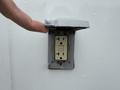 A 2011 Ford F-650 with a finger pointing at an electrical outlet mounted on the vehicle