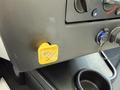 A yellow parking release button labeled Push located on the dashboard of a 2022 Lion Lion6 vehicle