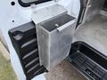 A metal storage container attached to the interior side of a 2016 GMC Savana van's cargo area