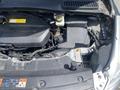 A top view of the engine compartment of a 2015 Ford Escape showing various components including the engine block coolant reservoir and air intake system