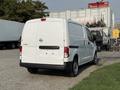 A white 2021 Nissan NV200 van is parked with its rear visible showcasing a simple design and sliding side doors