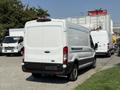 A white 2022 Ford Transit van is parked with its rear view visible showcasing its large cargo space and sleek design