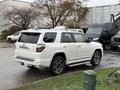 A white 2018 Toyota 4Runner parked with a sleek design and dark alloy wheels showcasing its robust SUV features