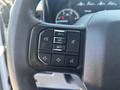 Steering wheel control panel of a 2023 Ford F-350 SD with buttons for audio and cruise control settings
