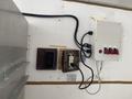 A 2008 Wells Industries Inc EW1422 features multiple switches and electrical outlets mounted on a wall with visible wiring connections