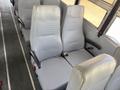 Two rows of gray bus seats designed for a 2009 International 3000 CE with seatbelts and armrests
