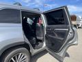 A 2018 Toyota Highlander with a rear door open revealing the interior seats and black upholstery
