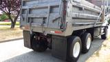 A grey 2003 International 5600i dump truck with a metallic body and dual rear wheels is parked with its back end facing the viewer