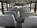 Interior view of a 2022 Freightliner B2 school bus featuring gray upholstered seats arranged in rows with visible aisle space