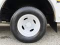 Close-up of a white tire mounted on a grey wheel of a 2012 Ford Econoline van showcasing its tread and lug nut design