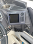 A Lowrance HDS 5 fishfinder display mounted on a boat dashboard with a black screen and various buttons visible