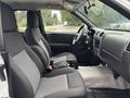 Interior of a 2011 Chevrolet Colorado featuring two front seats with fabric upholstery and a dashboard with controls and gauges visible