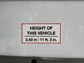 A sign on a vehicle stating the height of the 2020 Chevrolet Express as 3.43 m or 11 ft 3 in