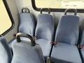 Interior view of a 2017 Chevrolet Express with blue upholstered passenger seats featuring seat belts and sturdy metal handles