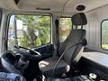 Interior of a 2012 Autocar Xpert showing the driver's seat steering wheel and control panel with a black fabric seat and the driver's side window open