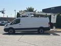 A 2019 Ford Transit 350 van with an extended aerial lift mounted on top and a sign holder attached at the back