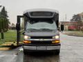 A front view of a 2019 Chevrolet Express with the passenger door open and a wheelchair ramp deployed